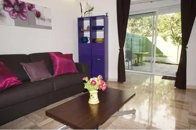 a living room with a couch and a table with flowers at CANNES POINTE CROISETTE Garden & Beach in Cannes