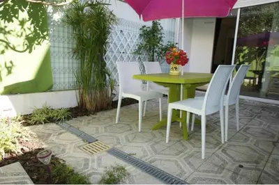 a patio with a table and chairs and an umbrella at CANNES POINTE CROISETTE Garden & Beach in Cannes