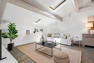 a living room with a white couch and a table at Appartement Reyer - Welkeys in Cannes