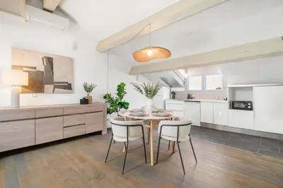a kitchen and dining room with a table and chairs at Appartement Reyer - Welkeys in Cannes
