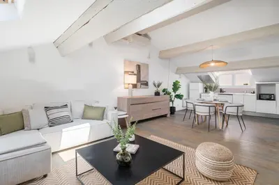 a living room with a white couch and a table at Appartement Reyer - Welkeys in Cannes