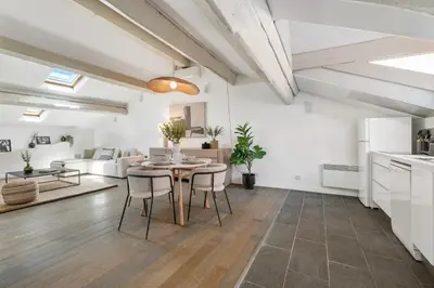 a kitchen and living room with a table and chairs at Appartement Reyer - Welkeys in Cannes