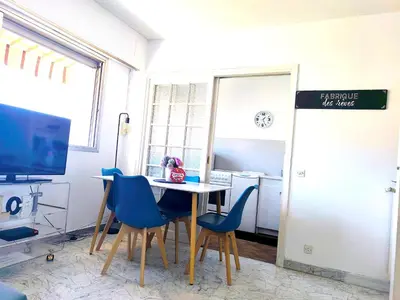 a dining room with a table and blue chairs at Quadruple bedroom apartment in Cannes
