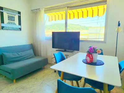 a living room with a table and a couch and a tv at Quadruple bedroom apartment in Cannes