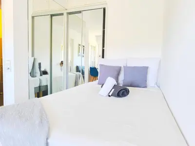 a white bed with a bag on top of it at Quadruple bedroom apartment in Cannes