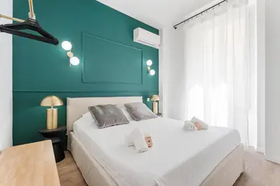 a bedroom with a white bed with a blue wall at Appartement Caire - Welkeys in Cannes
