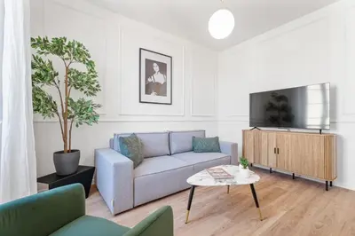 a living room with a couch and a tv at Appartement Caire - Welkeys in Cannes