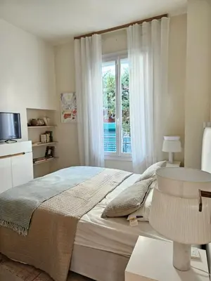 a bedroom with a large bed and a window at 3 bedroom house in the center of Cannes in Cannes