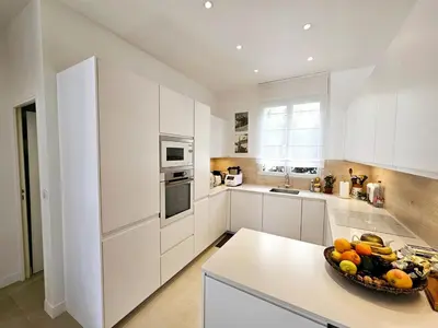a white kitchen with a bowl of fruit on a counter at 3 bedroom house in the center of Cannes in Cannes