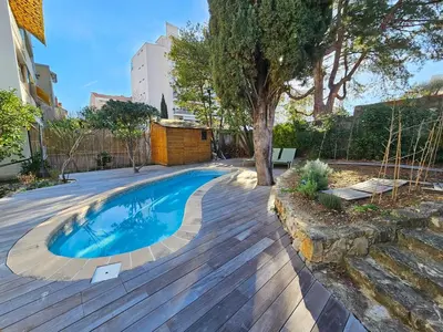 a backyard with a swimming pool and a tree at 3 bedroom house in the center of Cannes in Cannes