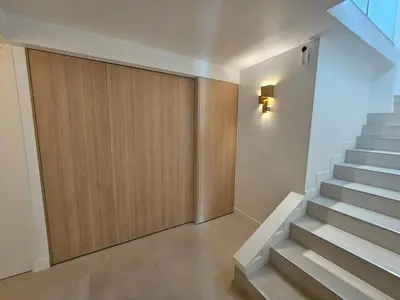 a hallway with stairs with a wooden door at 3 bedroom house in the center of Cannes in Cannes
