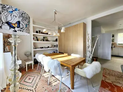a dining room with a wooden table and white chairs at 3 bedroom house in the center of Cannes in Cannes