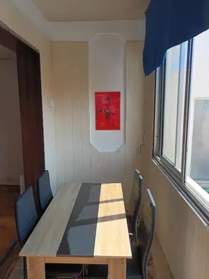 a table in a room with chairs and a picture at Appartement 2 chambres à Cannes entièrement rénové in Cannes