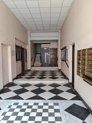 an empty hallway of a building with a checkered floor at Appartement 2 chambres à Cannes entièrement rénové in Cannes