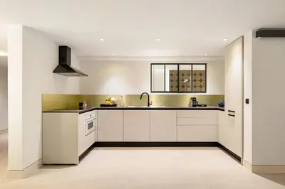 a kitchen with white cabinets and a window at Cèdre Bleu - Chic Peaceful Haven near Croisette in Cannes