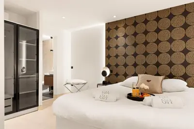 a bedroom with a large white bed with a wall at Cèdre Bleu - Chic Peaceful Haven near Croisette in Cannes