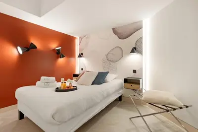 a bedroom with a white bed and a chair at Cèdre Bleu - Chic Peaceful Haven near Croisette in Cannes
