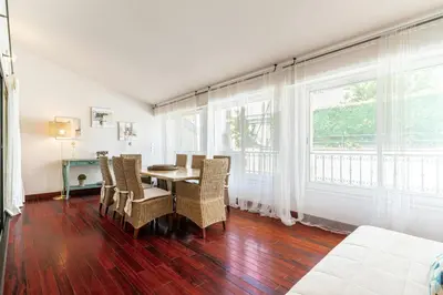 a dining room with a table and chairs and windows at Cannes Centre Le bourbon 1min mer et Croisette in Cannes