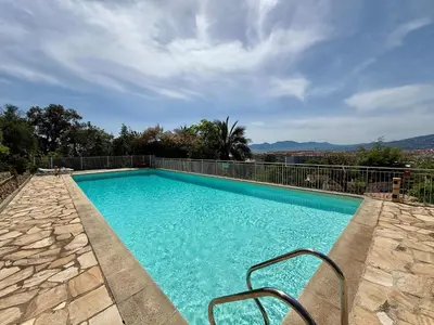 a swimming pool with blue water and a fence at B084-Confort et serenite piscine et stationnement in Cannes