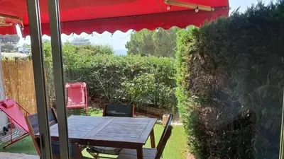 a table and chairs under a red umbrella at B084-Confort et serenite piscine et stationnement in Cannes