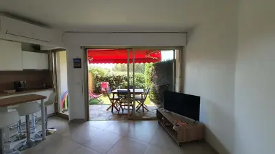 a kitchen and a dining room with a table and an umbrella at B084-Confort et serenite piscine et stationnement in Cannes