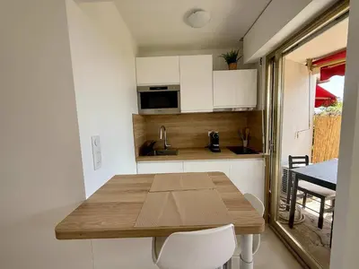a kitchen with a wooden table in a tiny house at B084-Confort et serenite piscine et stationnement in Cannes