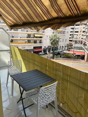 a table and chairs on a balcony with a view of a city at Cannes Croisette in Cannes