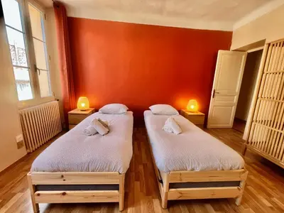 two twin beds in a room with orange walls at Belle-epoque apartment ,3bedrooms with sea view in Cannes