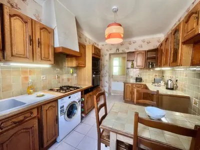 a kitchen with wooden cabinets and a washer and dryer at Belle-epoque apartment ,3bedrooms with sea view in Cannes