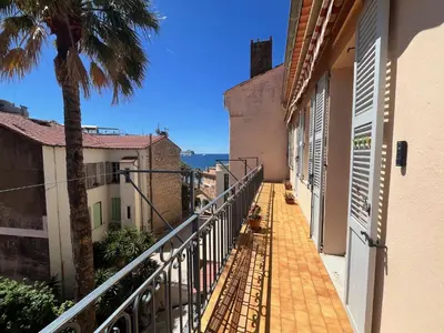 a balcony in a building with a palm tree at Belle-epoque apartment ,3bedrooms with sea view in Cannes