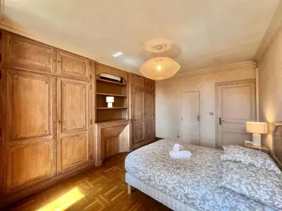 a bedroom with a bed and wooden cabinets at Belle-epoque apartment ,3bedrooms with sea view in Cannes