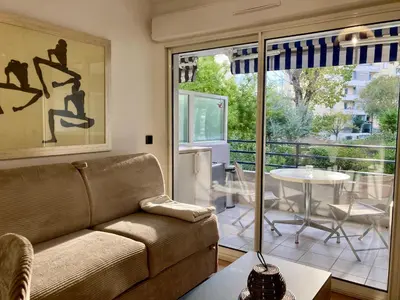 a living room with a couch and a table at Studio neuf parking piscine à Cannes in Cannes