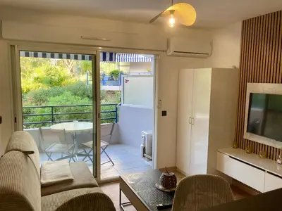 a living room with a couch and a television at Studio neuf parking piscine à Cannes in Cannes