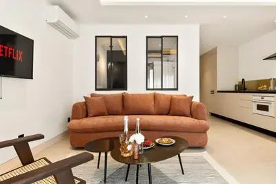 a bedroom with two beds and two windows at Suite L Ecrin Élégance confort au cœur de Cannes in Cannes