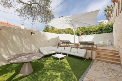 a patio with a couch and a table and an umbrella at Immogroom - Luxury Villa with Swimming Pool in City Center in Cannes