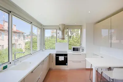 a kitchen with white counters and large windows at Immogroom - Luxury Villa with Swimming Pool in City Center in Cannes
