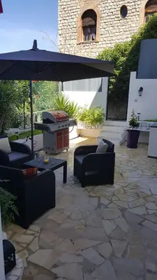 a patio with couches and an umbrella and a grill at villa matama in Cannes
