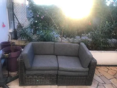 a couch sitting on a patio in a garden at villa matama in Cannes