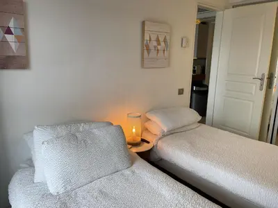 a room with two beds and a candle on a table at Cannes Beach Residence vue mer et pisicne in Cannes