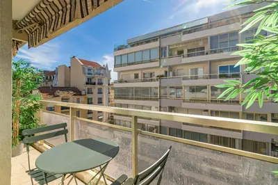 a balcony with a table and chairs and a building at REF 2011 - Cannes - Apartment for rent in Cannes