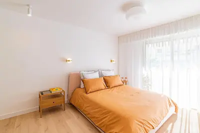 a bedroom with a bed with a night stand next to a window at REF 2011 - Cannes - Apartment for rent in Cannes