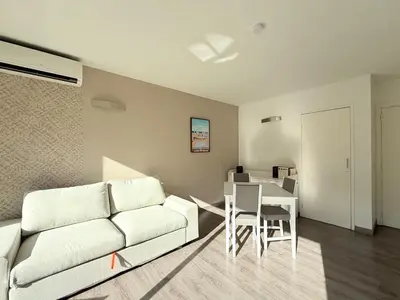 a living room with a couch and a table at 25m2 - Coeur De Ville, Vue mer in Cannes