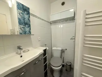 a white bathroom with a toilet and a sink at 25m2 - Coeur De Ville, Vue mer in Cannes