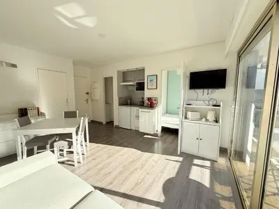a living room with a table and a dining room at 25m2 - Coeur De Ville, Vue mer in Cannes