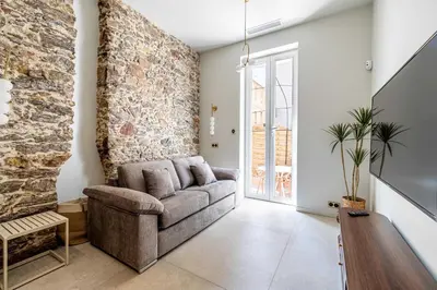 a living room with a couch and a stone wall at Magnificent apartment - AC-1BR-4P- Cannes in Cannes