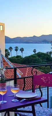 a table with two wine glasses on top of a balcony at Belle vue mer in Cannes
