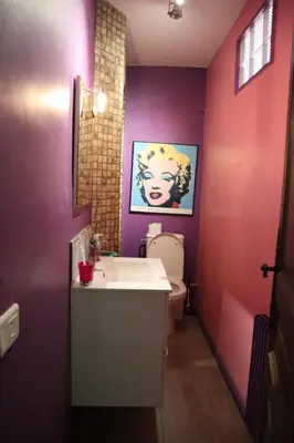 a bathroom with purple walls and a sink and a toilet at Belle vue mer in Cannes