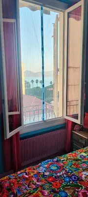 a bedroom with a large window with a view of a city at Belle vue mer in Cannes