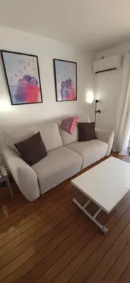 a living room with a white couch and a table at Élégant cocon sur la croisette parking terrasse et jardin in Cannes