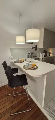 a kitchen with a white counter and a sink at Élégant cocon sur la croisette parking terrasse et jardin in Cannes